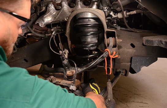 Chris from O’Reilly Auto Parts lifting the new strut into place on the 2011 Chevy Silverado